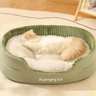 On vpoit un chat angora blanc et roux qui est allongé dans un panier en peluche kaki très moderne.