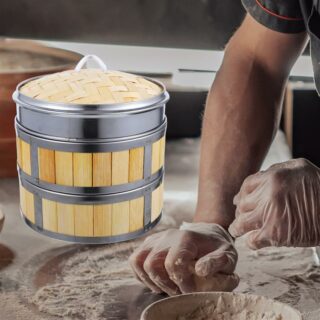 Main d'un homme en train de pétrir une pâte avec un panier en bambou à côté