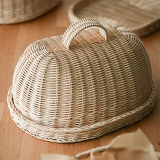 Panier en rotin avec un couvercle posé sur une table
