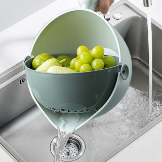 Bol et passoire dans un évier avec des raisins verts dedans avec de l'eau qui sort du bol
