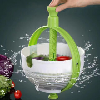 Main poussant un manche vert qui fait tourner un panier à salade blanc avec des fruits dedans avec des gouttes d'eau qui sortent du panier