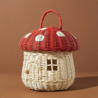 Panier en forme de champignon rouge et blanc sur fond orange.