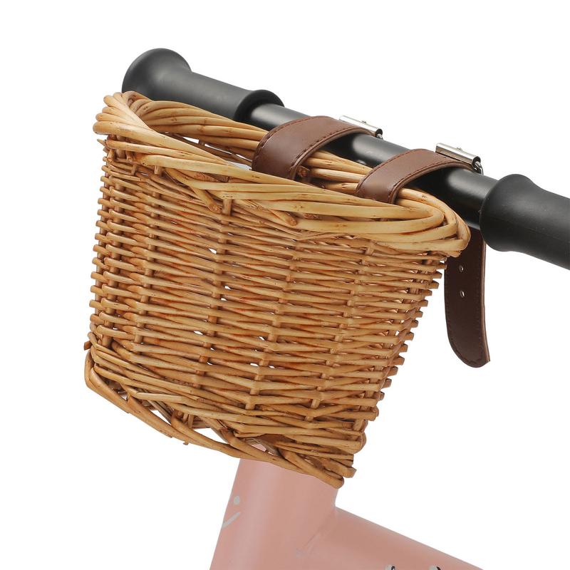 6334-ghnbtn.jpg Un panier de vélo en osier beige fixé avec des sangles sur le guidon d'un vélo rose.