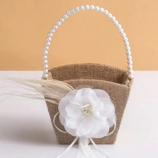 Panier mariage en toile de jute style rustique ici sur une table blanche sur un fond orange.