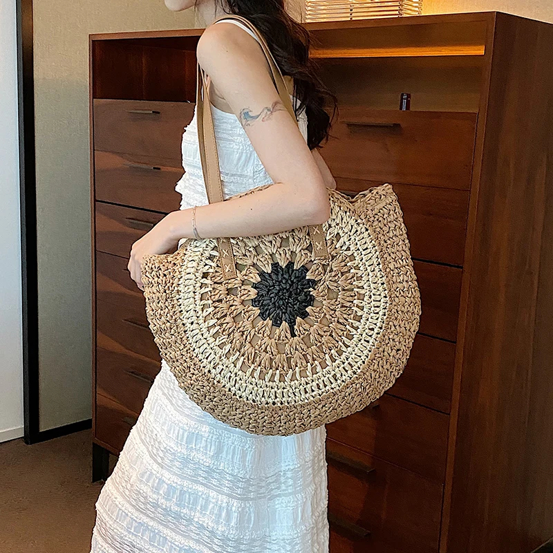 Panier de plage tricolore de forme arrondie ici porté par une femme dans une pièce.