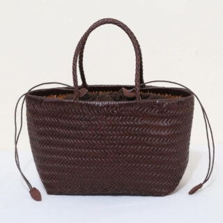 Panier de plage en cuir avec poignées sur fond gris