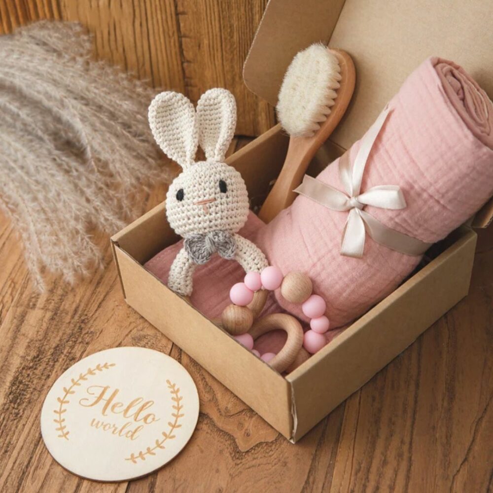 Panier naissance thème lapin avec hochets dans une boite sur fond marron