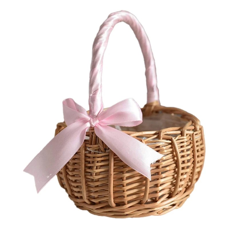 IMG_07_2024_Panier_à_fleurs_avec_petit_nœud_1.jpeg Panier tressé de petite taille, avec un ruban rose et un nœud en satin qui entour l'anse du panier.