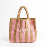 Panier de plage avec des bandes roses et marrons ici sur un fond blanc.