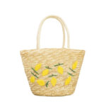 Panier de plage avec des motifs citron ici sur un fond blanc.