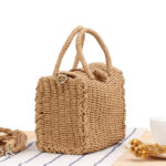 Panier de plage en rotin style vintage ici posé sur une nappe.